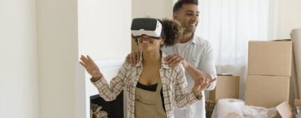 a couple walks through their house with VR goggles to see virtual staging