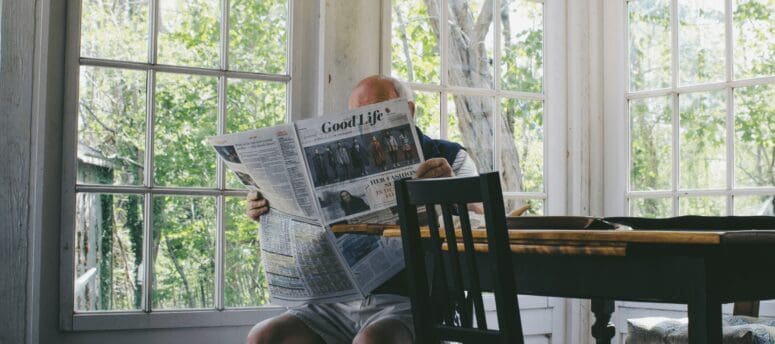 elderly parent reading the newspaper after moving in with child