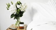 Flowers on a nightstand that represent simple staging in a bedroom.