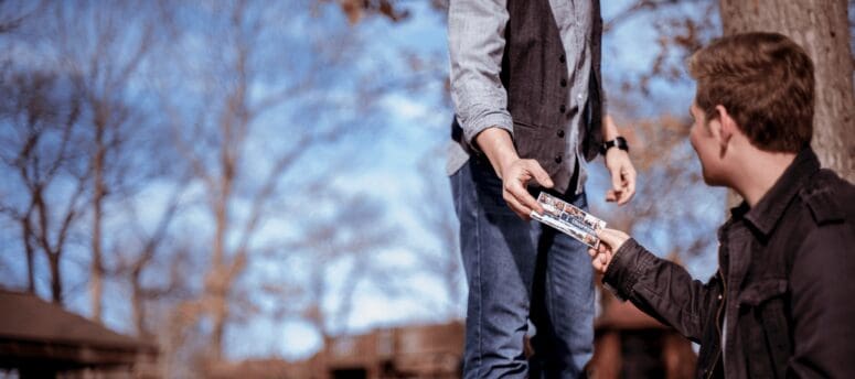 someone hands a young man an open house invitation