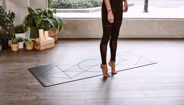 A woman doing yoga in her home with new flooring.