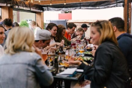 A group of millennials at a dinner discussing home buying.