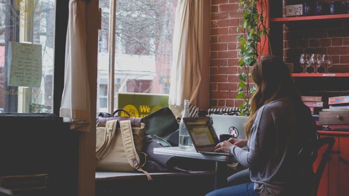 Woman in coffee shop reviewing home inspection report.