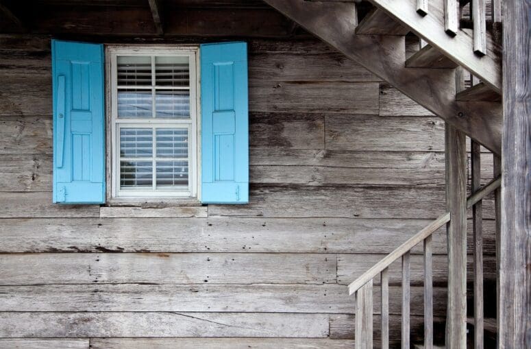 Brown house with blue shutters before home inspection.