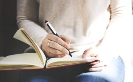 Woman writing home inspection tips on notepad.