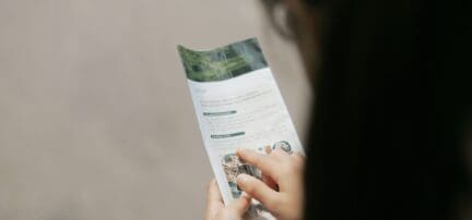 A woman reading an open house brochure.