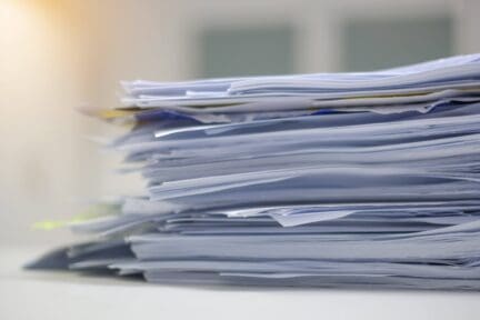 A pile of papers that are stored as home records.