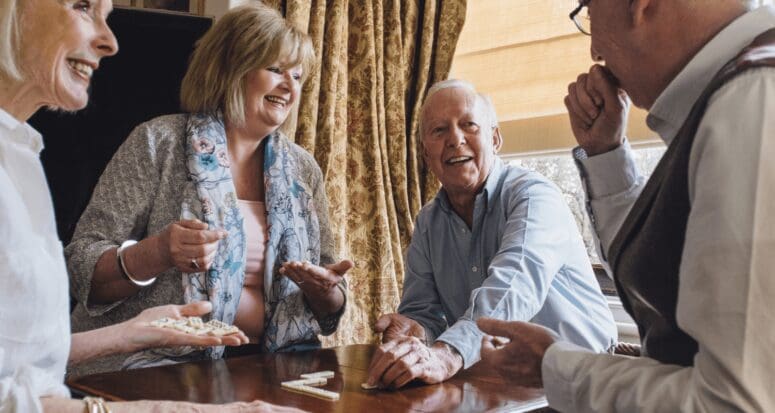 A group of retirees playing in dominoes in a retirement home.