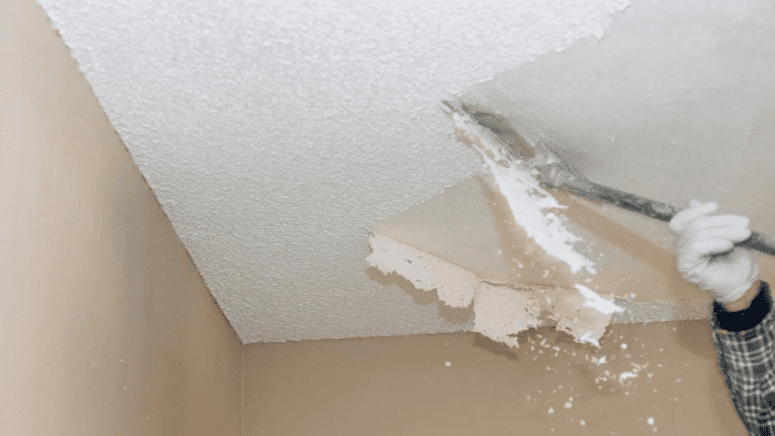 A man removing popcorn ceiling to increase home value.