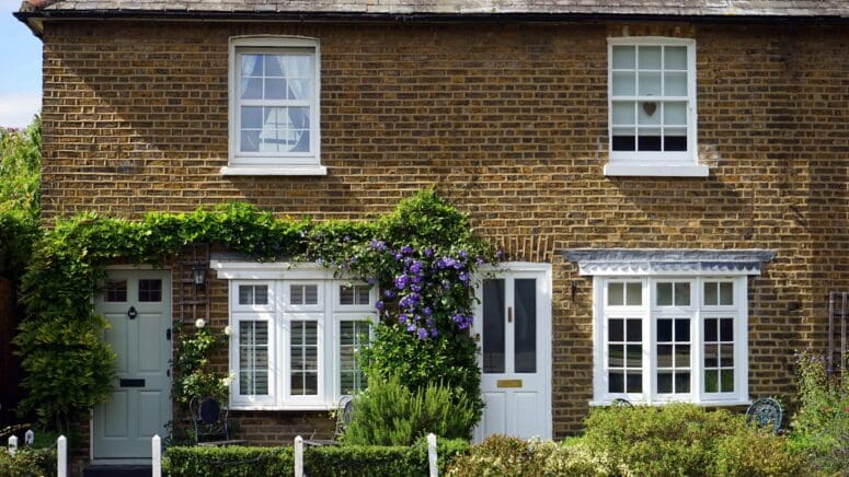 A white door on a brick house.