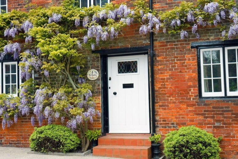 A white front door on a brick house.