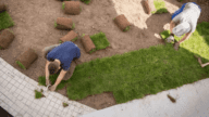 A person fixing their bad yard with new sod to sell a house.