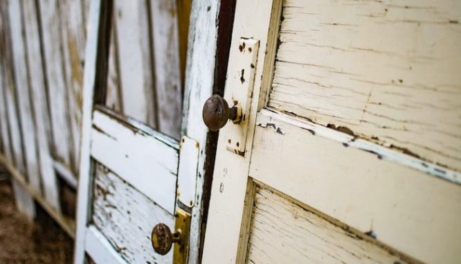 Two old doors leaning against a wall