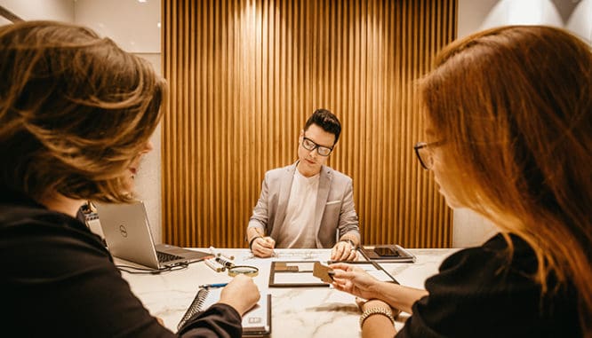 Two women and one man working in an office.