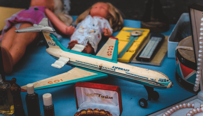 A toy plane, baby dolls, and other assorted old toys.