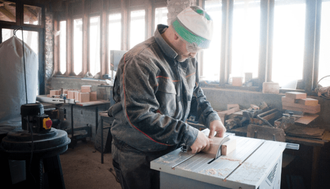 A handyman using a saw to cut wood.