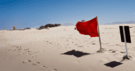 A red flag on a beach.