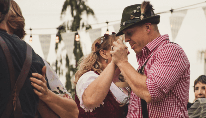 A man and woman dancing for Oktoberfest in Nashville, where you can buy a house.