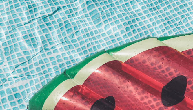 A watermelon shaped flotation device in a pool.