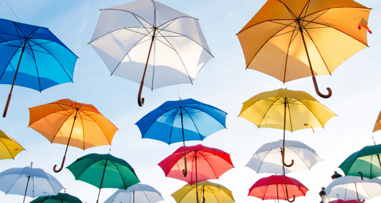 Several colored umbrellas hanging in the sky.