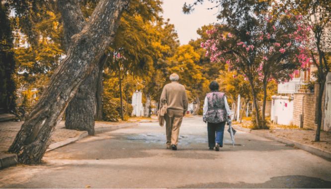 Two seniors discussing moving tips on a walk.