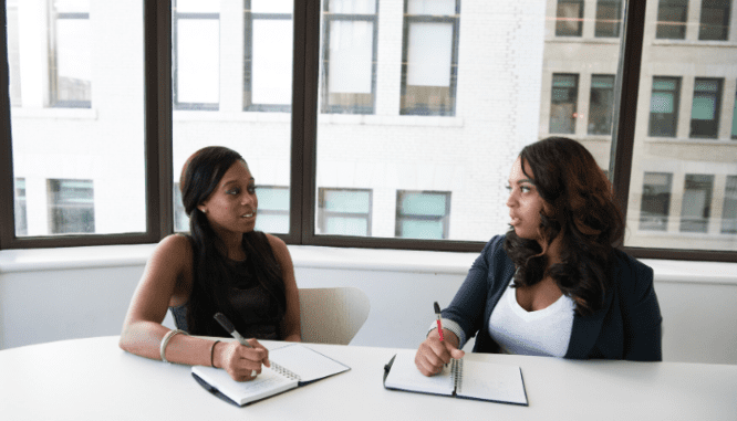 Two women discussing a reasonable offer that's below listing price.