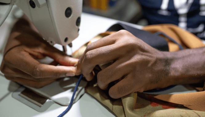 Hands that are working at a sewing machine.