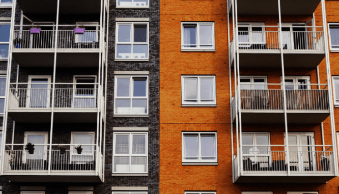 Two apartment buildings right next to each other and all the windows and balconies