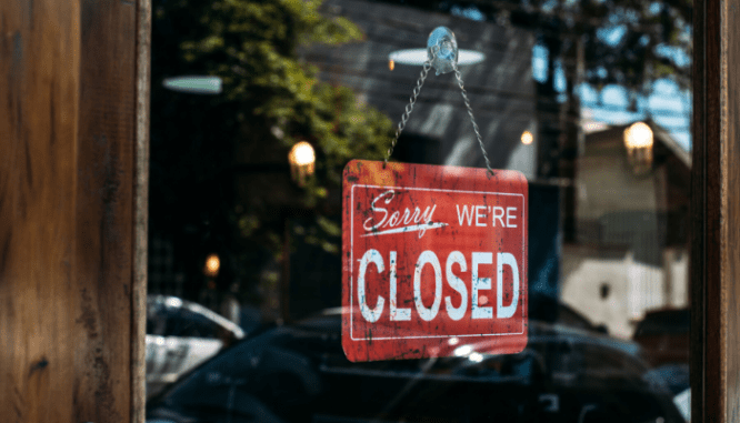 A red "Sorry, we're closed" sign in a window due to coronavirus. .