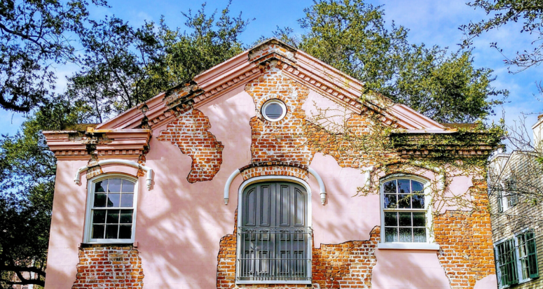 A red brick house with pink plaster spots still left on top you could be packing to move into.