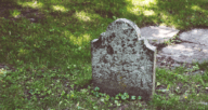 A headstone in a cemetery that you could have property next to.