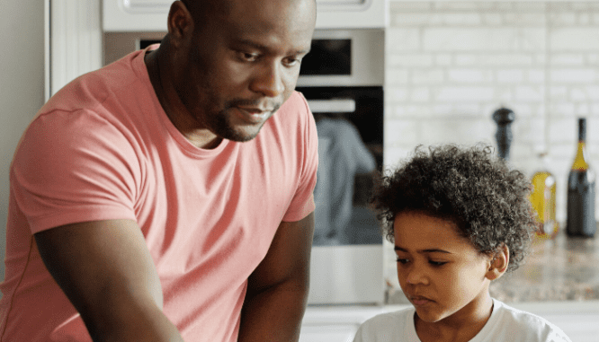 A man and his son in a kitchen cooking together without buyer's remorse.