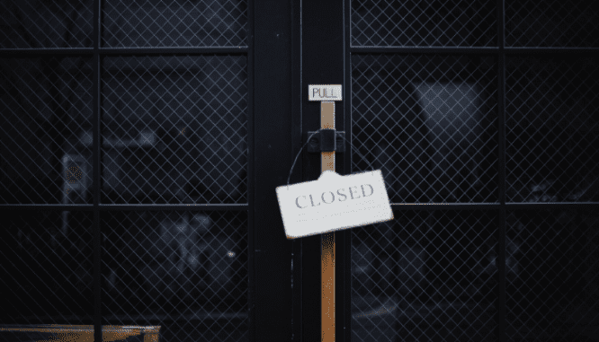 A closed sign in front of a store.