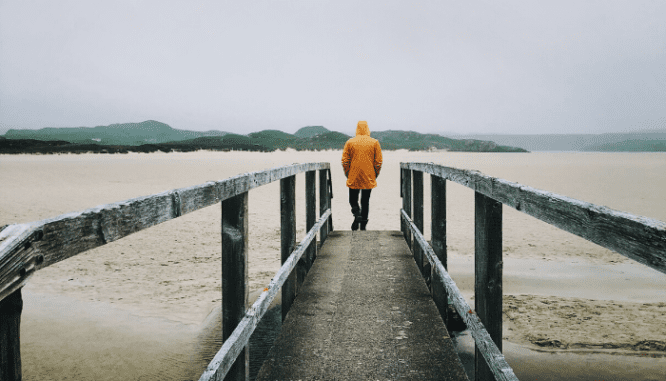 A person walking away from an underwater house.