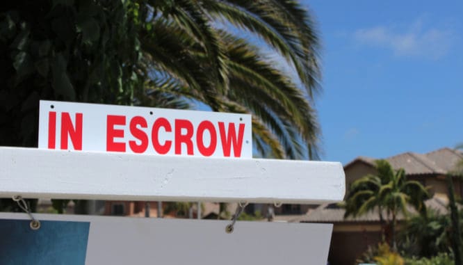 An escrow sign outside a home representing the escrow closing documents