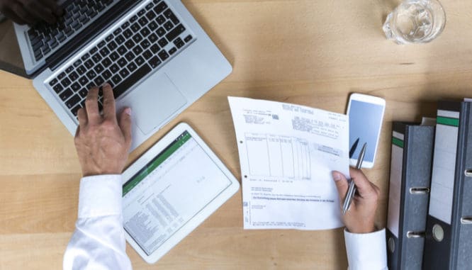 A man working at a computer on tax declarations, some of the closing documents you need