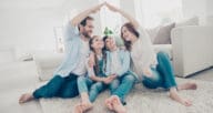 Parents holding their arms over children in a house shape to symbolize home insurance; here's how to change home insurance