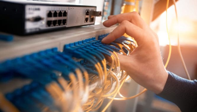 A hand switching cords between outlets to symbolize to change home insurance