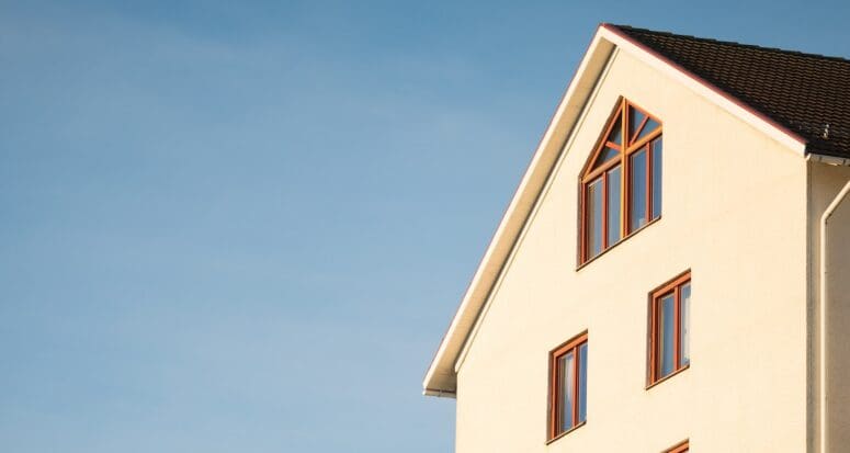 Morning sun shining on the side of a house represents how to invest 5000 dollars in real estate