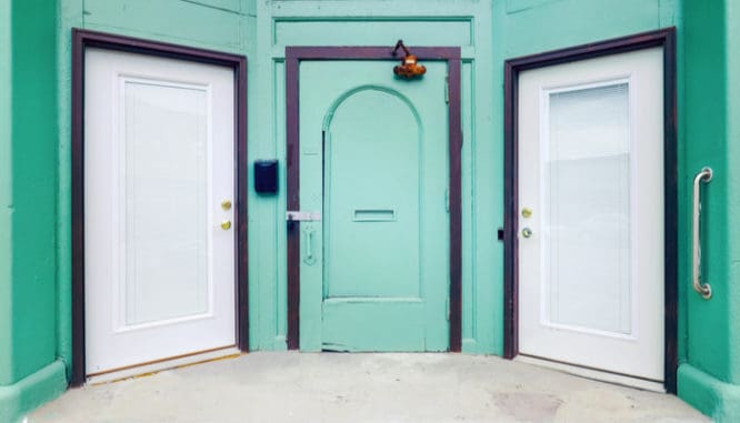 Three doors, one green and two white, to symbolize the difference between a mortgage broker, loan officer, and lender
