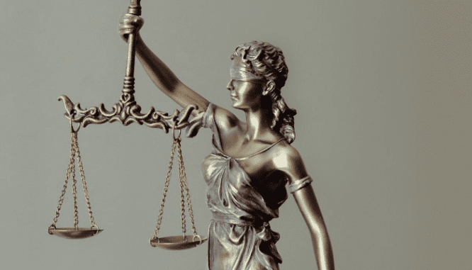A photo of the scales of Justice illustrate an executor's need for a lawyer.