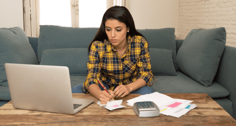 A woman looking at a computer to decide when to pay a mortgage payment.