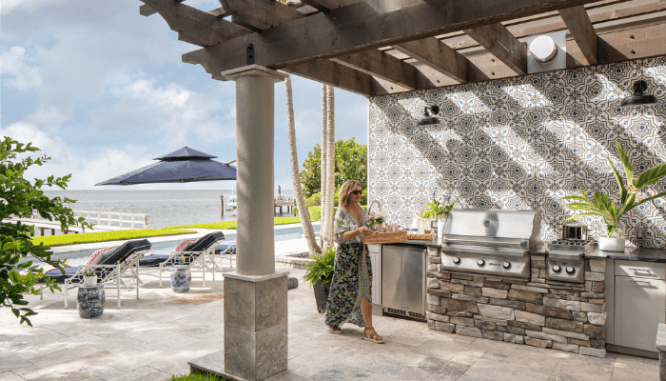 A woman walking through a backyard patio.