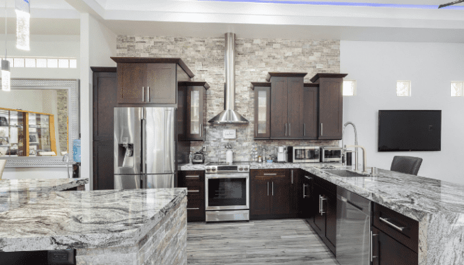 A grey kitchen with granite countertops.