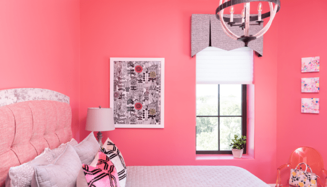 A pink room with a matching valence that is in style.