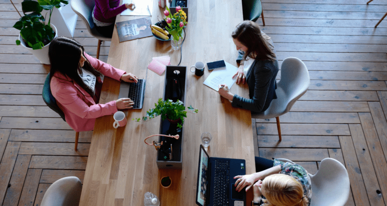 Women researching pmi rates on computers.