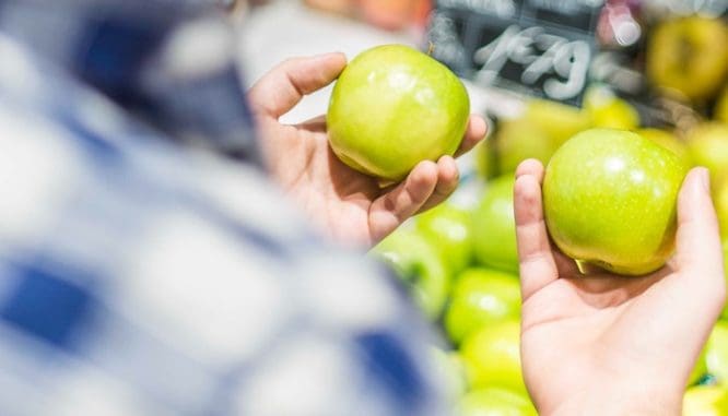 A man holding two apples is comparison shopping, which you want to do with mortgage rates