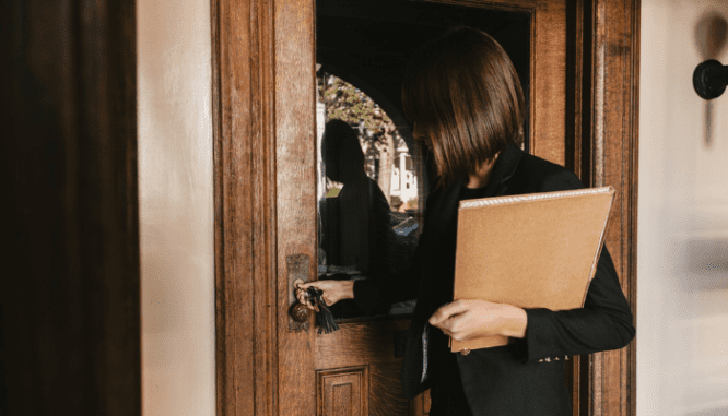 A real estate agent opening the door for a client.