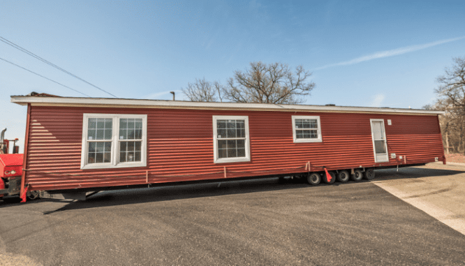 A manufactured home being towed to a new location.