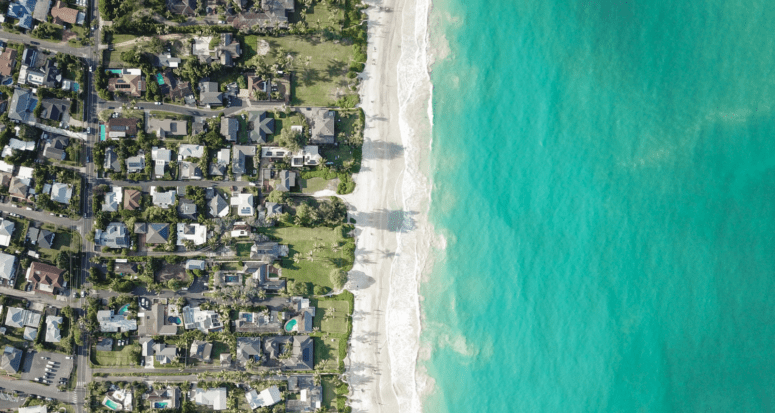 An aerial view of a housing market near the ocean.